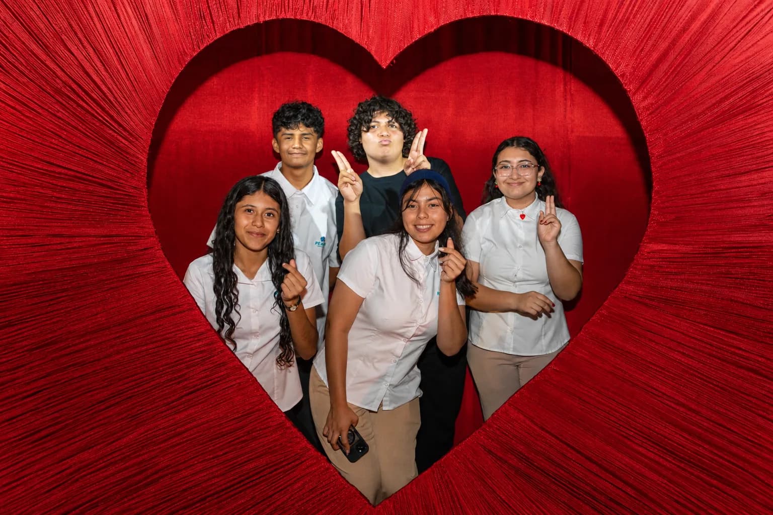 PEACE Punta de Mita beneficiaries smiling together inside a giant red heart